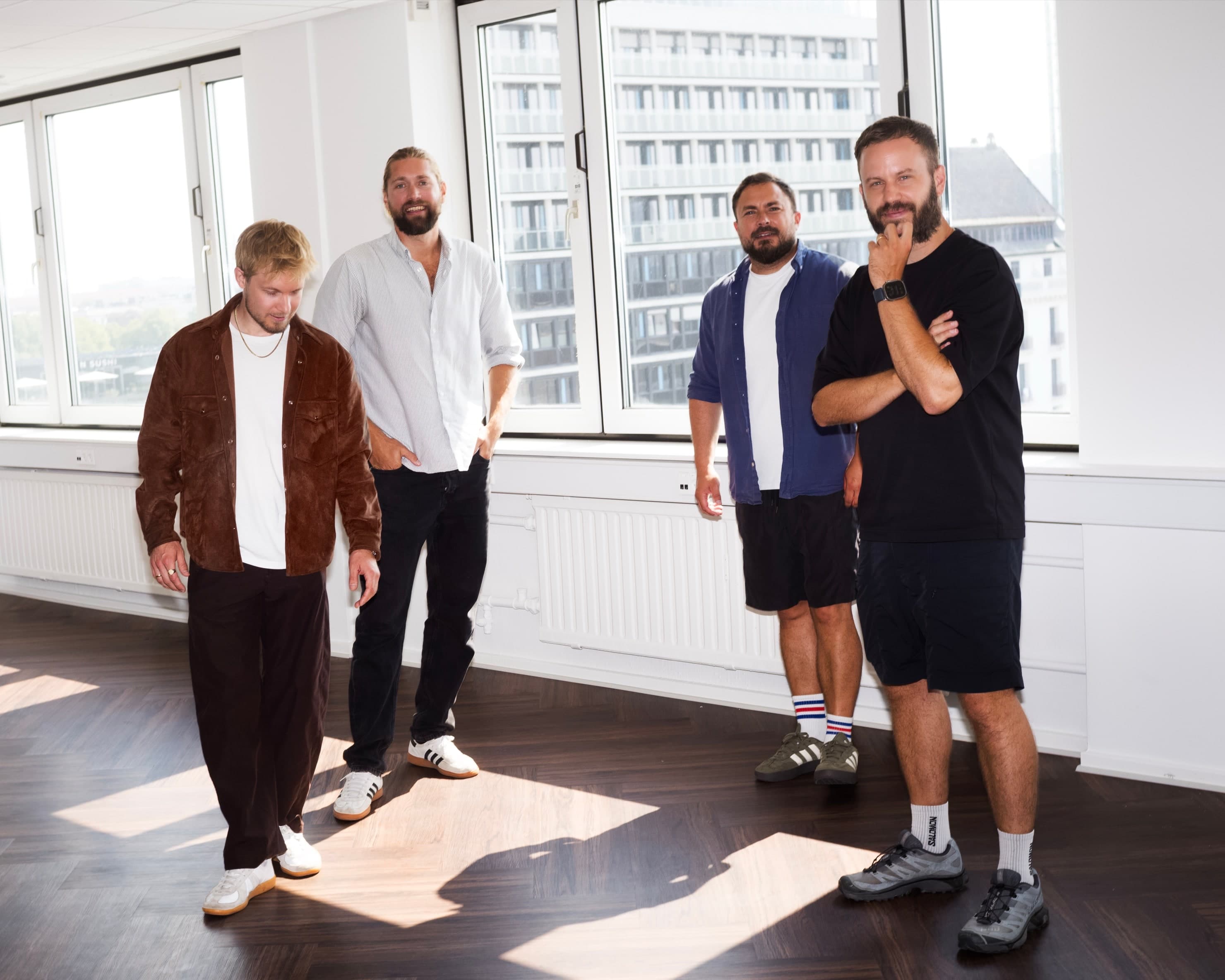 The four Palette founders spread across their sunlit Copenhagen office, sunlight falling across the herringbone floor.